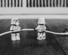 Star Wars legos holding a wire to connect to a phone.