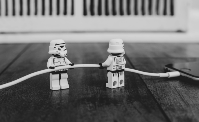 Star Wars legos holding a wire to connect to a phone.