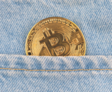 A bitcoin in the back pocket of a pair of jeans.