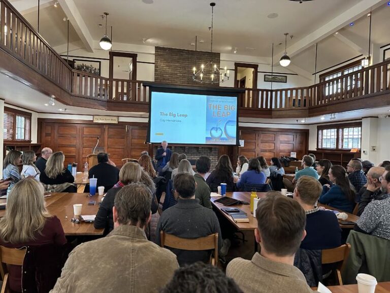 A group of people looking at a tv screen in a meeting.