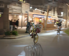 A skilled cyclist performing a daring stunt at night on a city street.