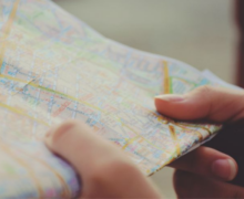 Close-up of hands holding and examining a folded map.