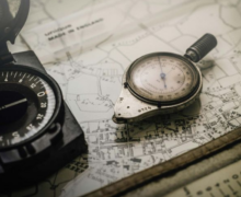 Vintage compass and measuring tool placed on a detailed map.