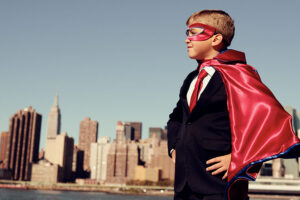 Boy in front of skyline wearing a disguise - cape and mask